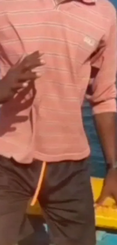 Man in casual attire on beach with ocean background.