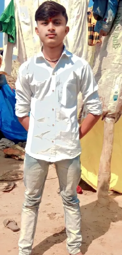 Man standing on sandy beach with colorful background.