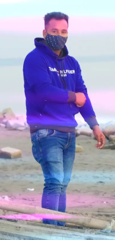 Man in blue hoodie on a serene beach