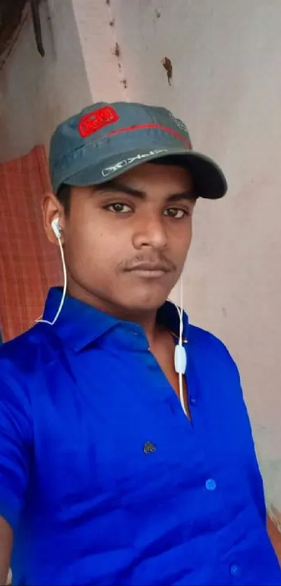 Young man in blue shirt with gray cap.