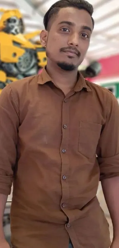 Man in a brown shirt posing with a vibrant blurred background.