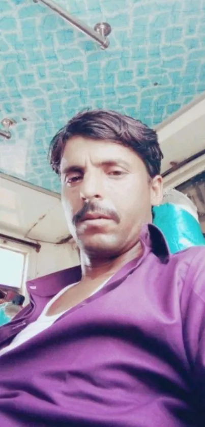 Person in a vibrant shirt sitting inside a colorful bus.