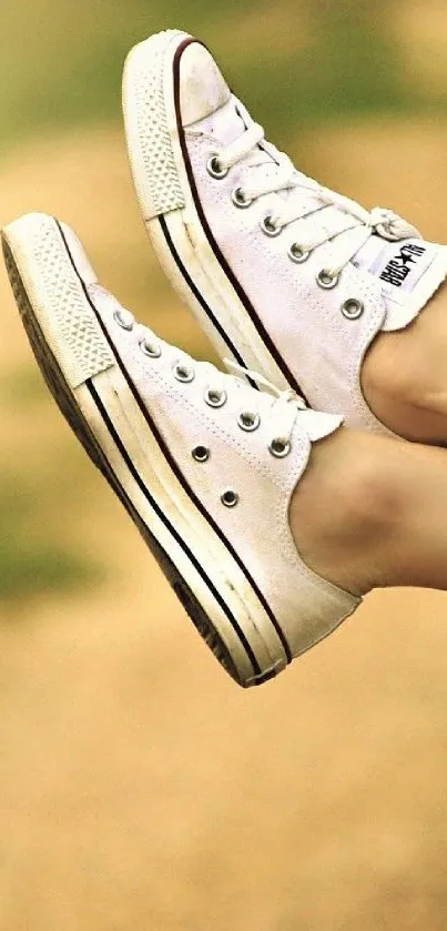 White Converse sneakers suspended mid-air mobile wallpaper.