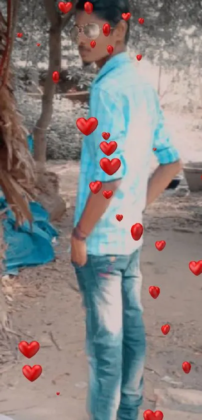 Man in jeans standing near a rustic hut.