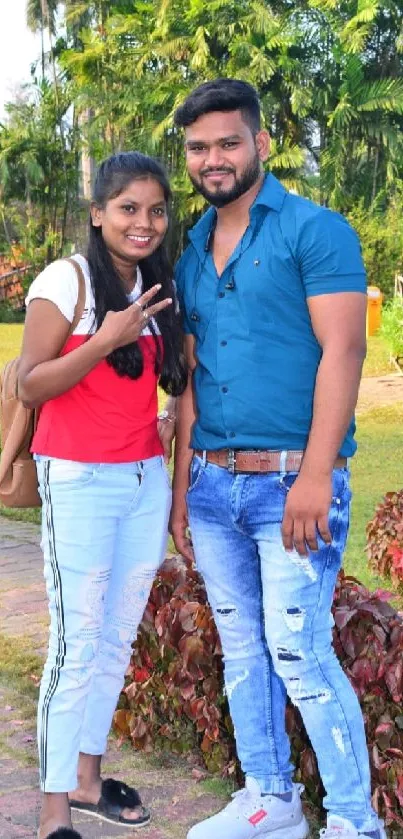 Couple in park with lush greenery and casual style.