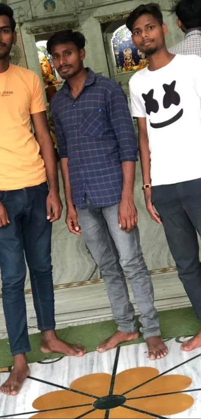 Three friends stand casually inside a temple.