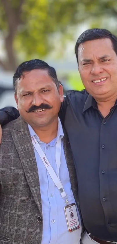 Two men smiling in an outdoor setting.