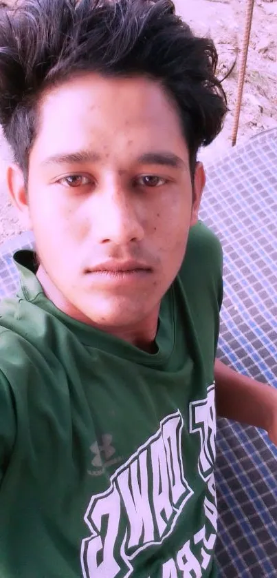 Young person in green shirt, casual outdoor portrait.