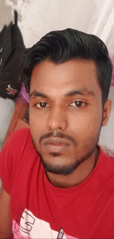 Casual portrait of a young man in a red shirt indoors.