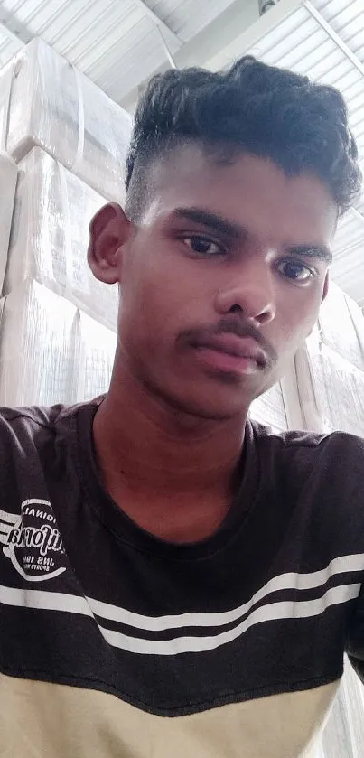 Young man in casual attire with light grey background indoors.