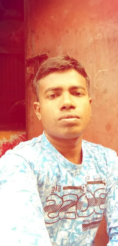 Casual portrait of a young man in a vibrant blue shirt indoors.