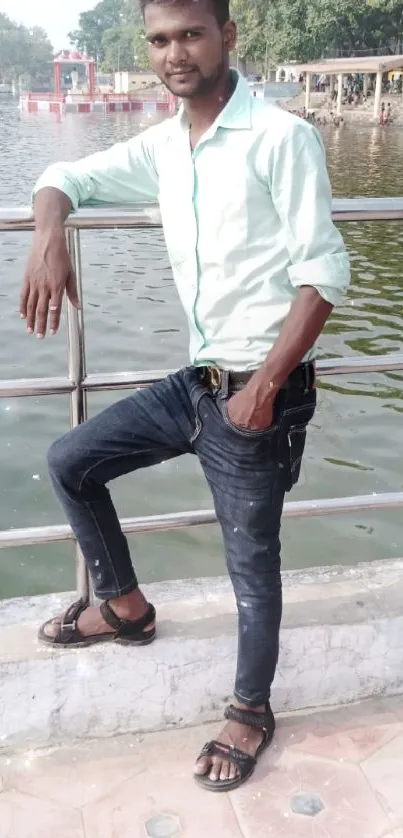 Man posing casually by the lakeside railing