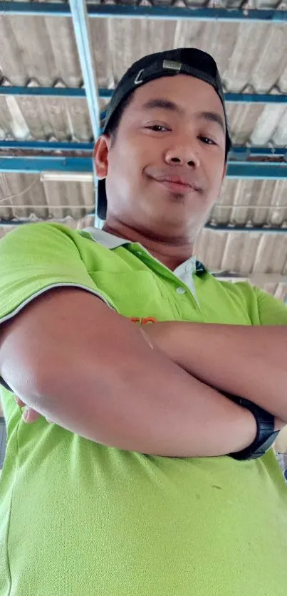 Confident person in green shirt standing indoors.