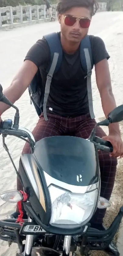 Biker on motorcycle posing on a rural road.