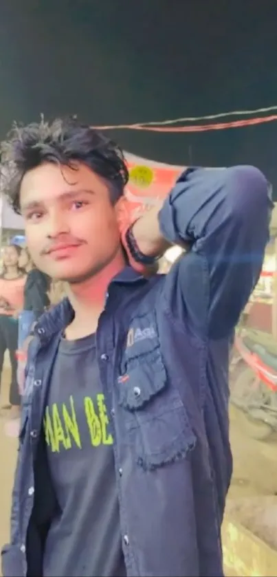 Young man at a bustling market with vibrant lights.