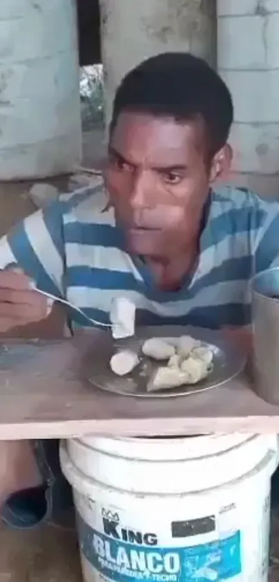 Man enjoying a meal outdoors with a serene backdrop.