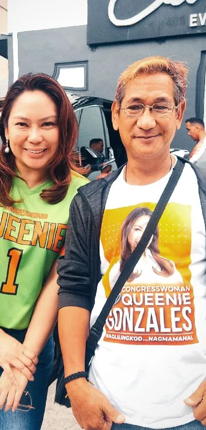 Two smiling people at an outdoor event.
