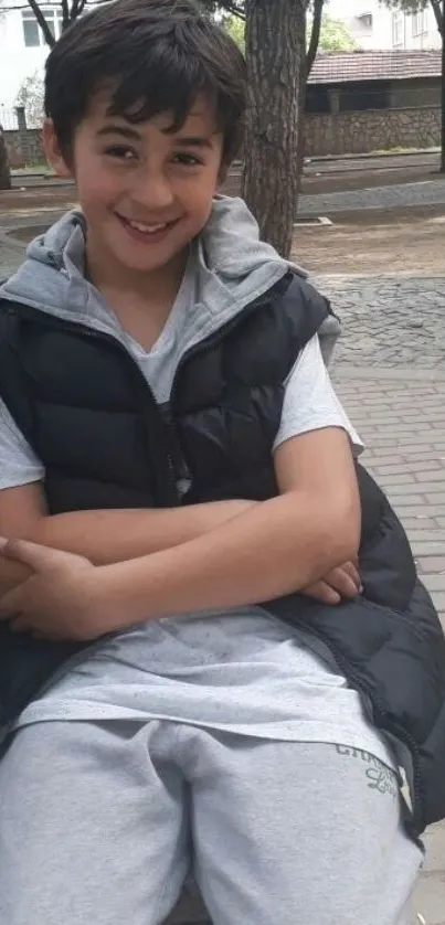 Young boy in casual wear, sitting on a park bench.