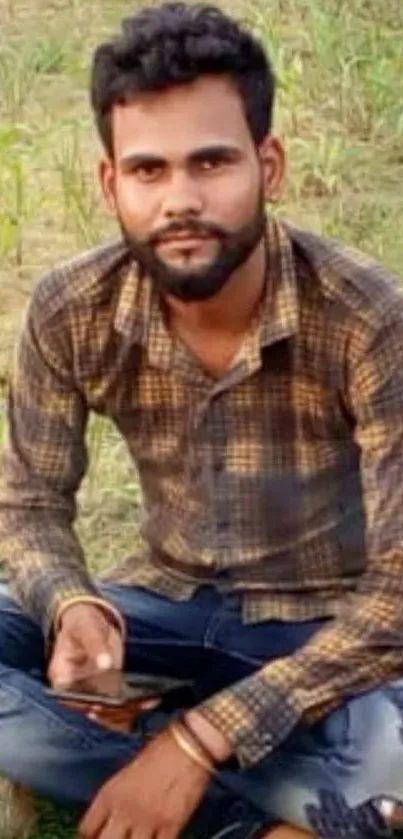 Casual portrait of a man sitting outdoors in a field.