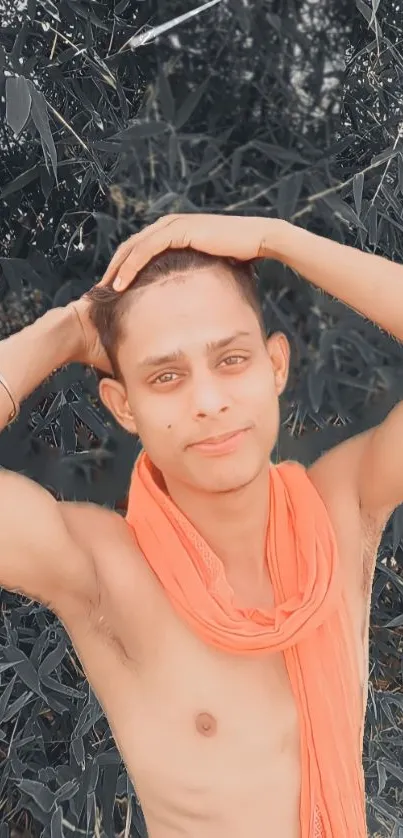 Outdoor portrait of a young man with an orange scarf.