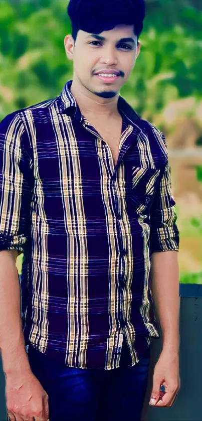 Young man in plaid shirt with green background.