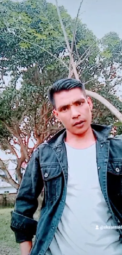 Casual outdoor portrait with denim against greenery.