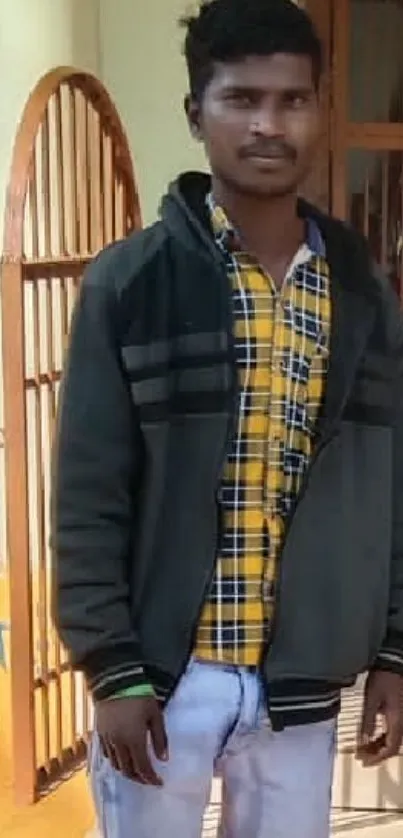 Young man standing outdoors in casual attire.