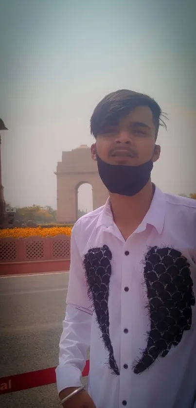 Young man posing outdoors with historic background.