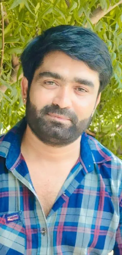 Portrait of a man outdoors with a natural green background.