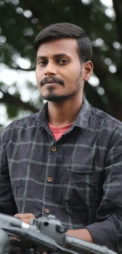Portrait of man outdoors with nature backdrop.