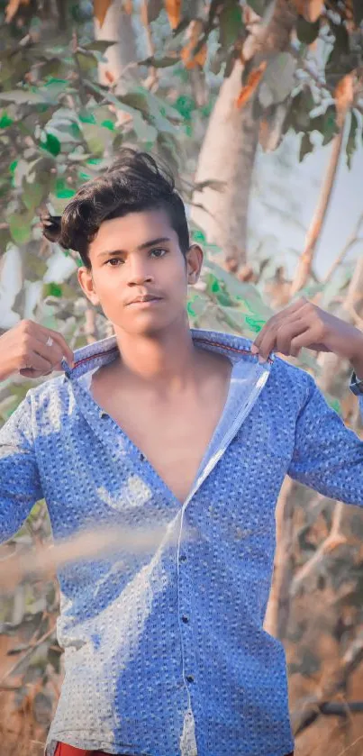 Casual portrait of a young man outdoors with a blue shirt.