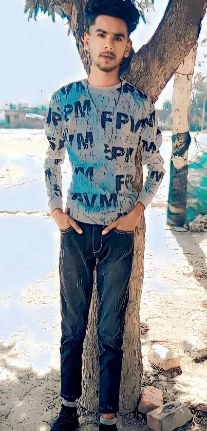 Young man standing by a tree outdoors.