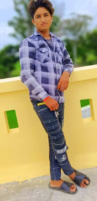 Young man in stylish outdoor portrait with yellow wall.