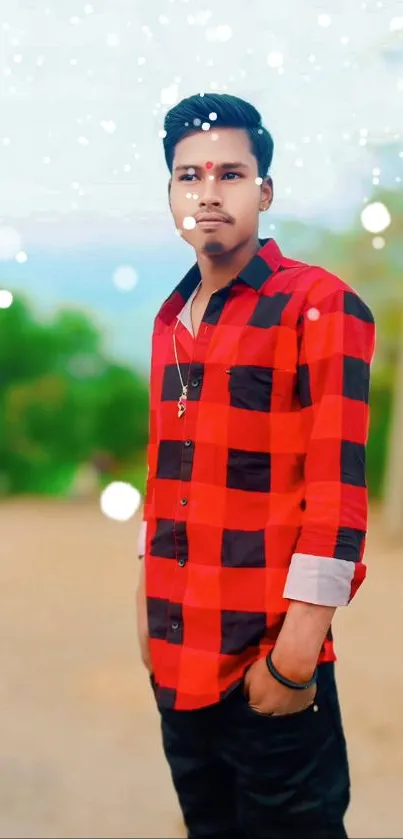 Outdoor portrait of a man in a red checkered shirt with a nature background.