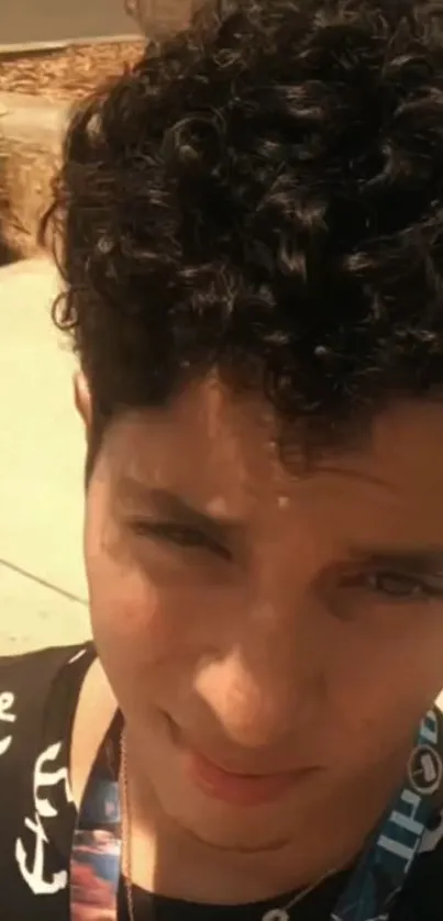 Casual outdoor portrait with curly hair.