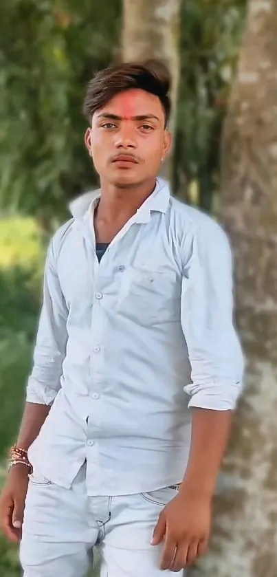 Young man in white shirt with green nature backdrop.