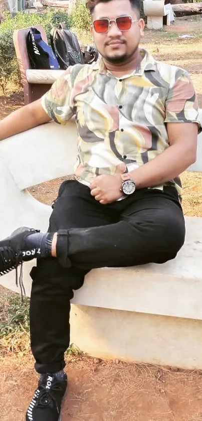 Casually dressed person relaxing outdoors on a park bench with a stylish outfit.