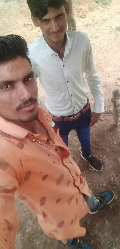 Two friends taking an outdoor selfie in casual attire.