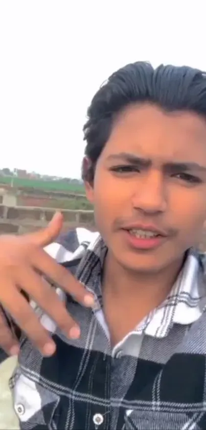 Young man taking a selfie outdoors with a casual and stylish look.