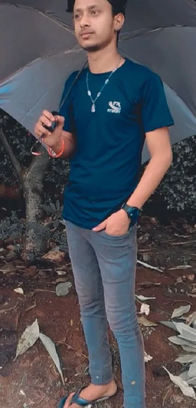 Man standing outdoors with umbrella.