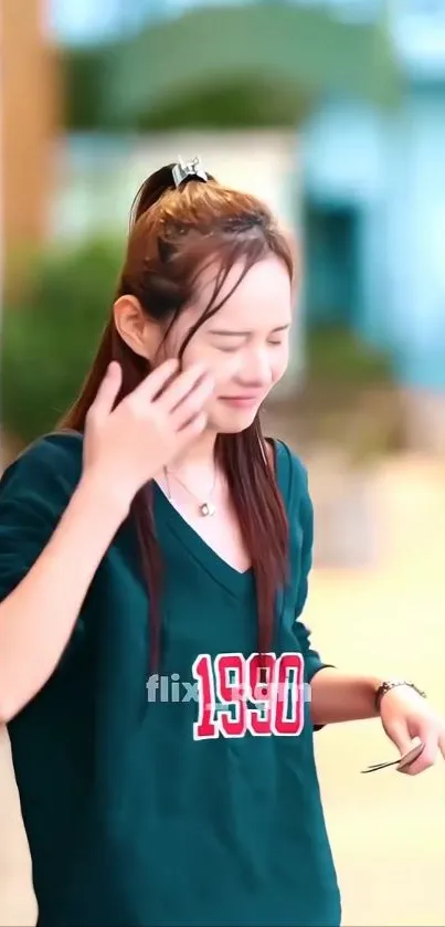 Young woman in a casual tee walking outdoors, daytime.