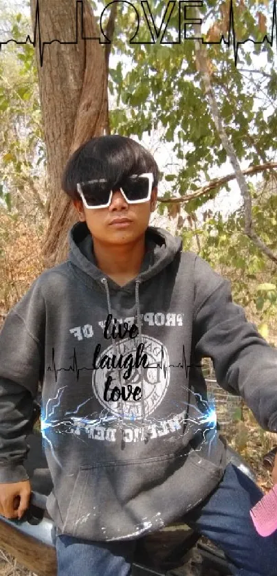 Stylish individual with sunglasses and hoodie outdoors.