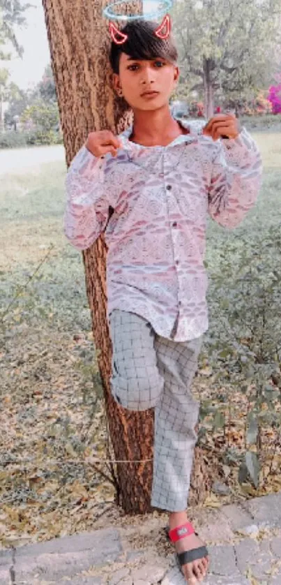 Casual young person posing outdoors with nature background.