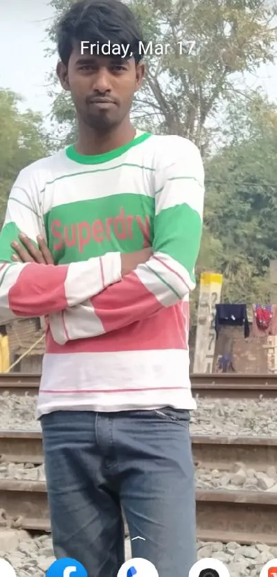 Casual outdoor scene with colorful attire by railway tracks.