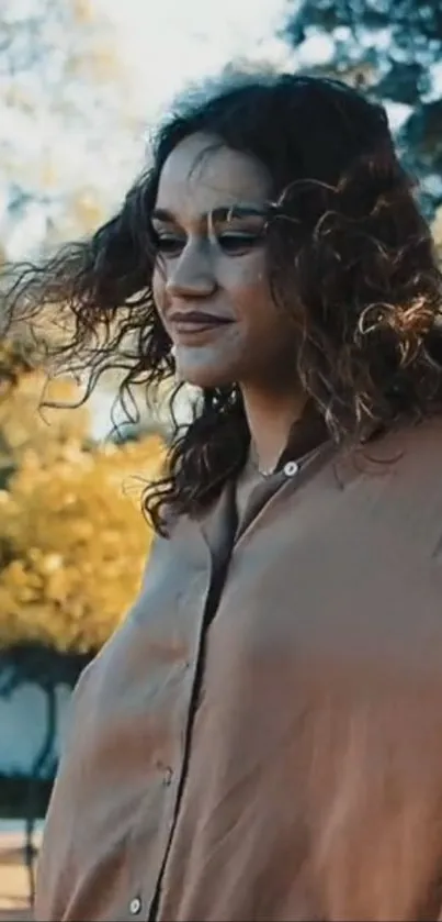 A person with wavy hair enjoying a sunny outdoor setting.