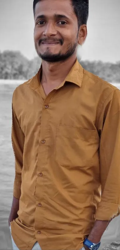 Portrait of a man in a brown shirt by a calm river.