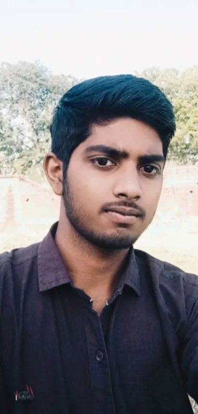 Casual portrait of a young man with a scenic background.