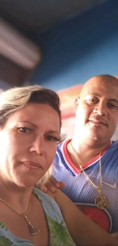 Casual portrait of two individuals on vacation with a vibrant blue background.