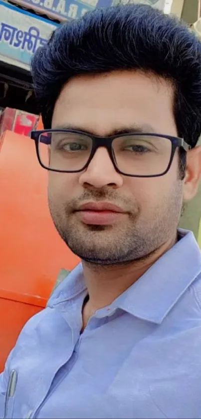 Casual portrait of a man with glasses and a blue shirt.