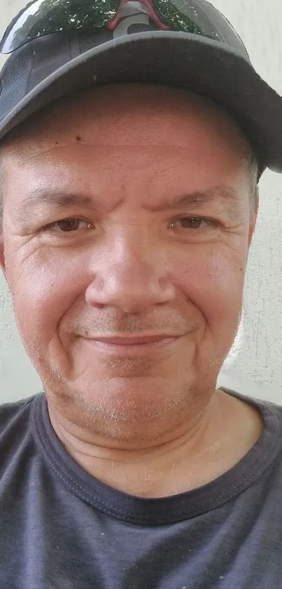 Portrait of a man in a black cap with a neutral background.